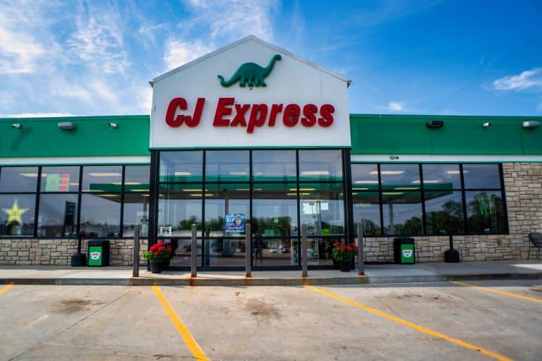 A green and white c express store in a parking lot.