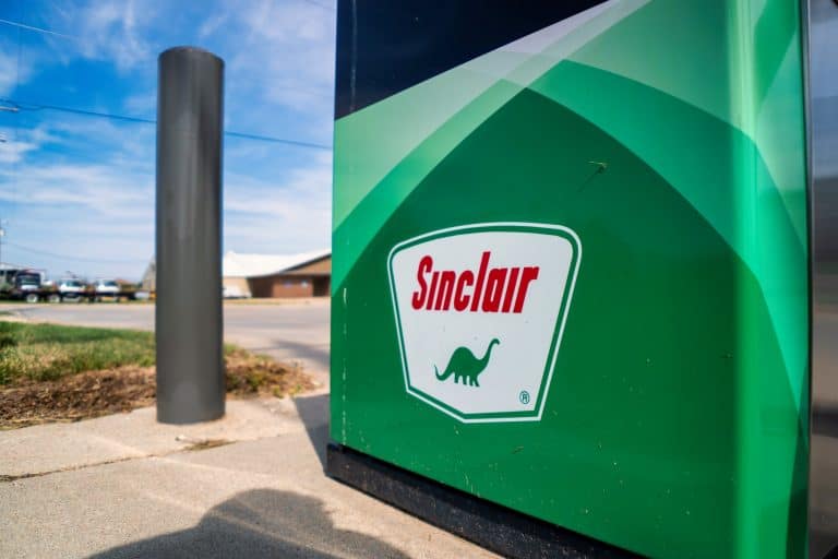 A gas station with a green sign on it.